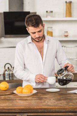 kahve fincan içine sabah mutfağa dökme tişörtlü yakışıklı adam