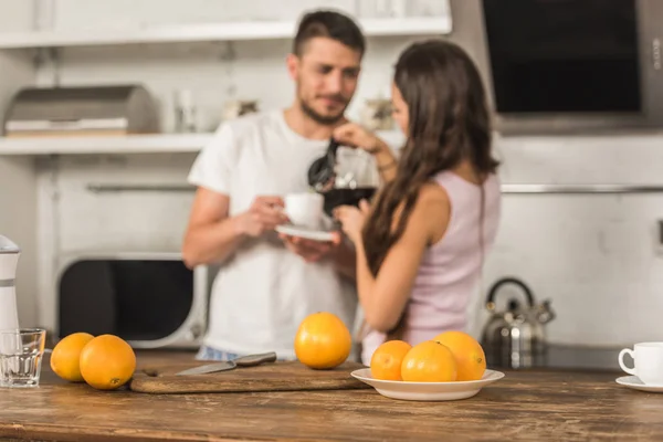 Selective Focus Girlfriend Pouring Coffee Boyfriend Cup Oranges Tabletop Kitchen — Free Stock Photo