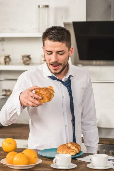 Handsome Man Eating Croissant Morning Kitchen — Free Stock Photo