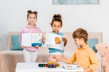 Resimler holding ve birlikte boya şirin çok ırklı çocuklar