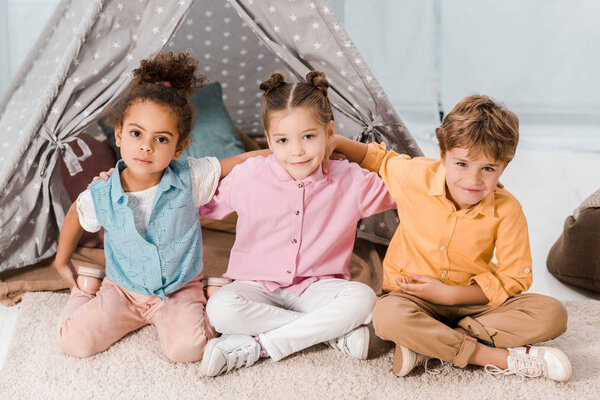 high angle view of cute little kids sitting together and smiling at camera
