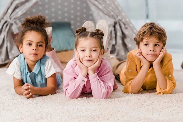 Hermosos Niños Multiétnicos Tumbados Alfombra Mirando Cámara — Foto de Stock