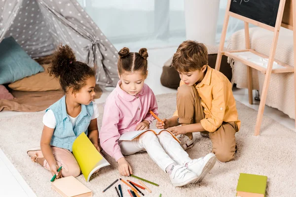 Vista Alto Ângulo Adoráveis Crianças Multiétnicas Sentadas Tapete Estudando Juntas — Fotografia de Stock