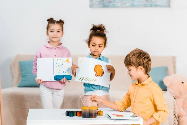 Lucu Multietnis Anak Anak Memegang Gambar Dan Melukis Bersama Sama — Foto Stok Gratis