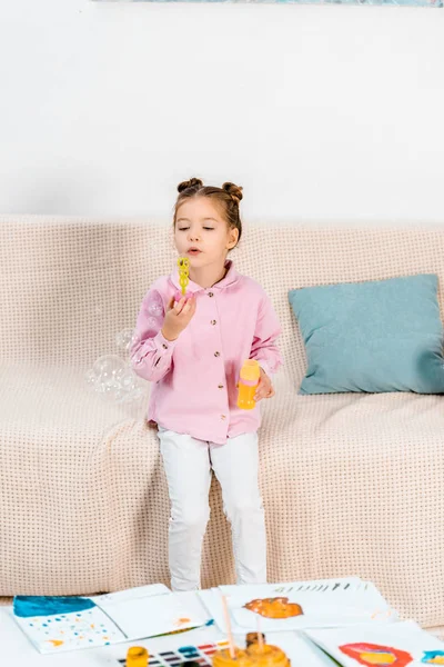 Adorable Child Sitting Couch Blowing Soap Bubbles — Free Stock Photo