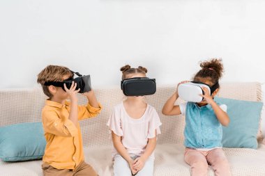 kanepe oturma ve sanal gerçeklik kulaklık kullanarak çok güzel küçük çocuklar  