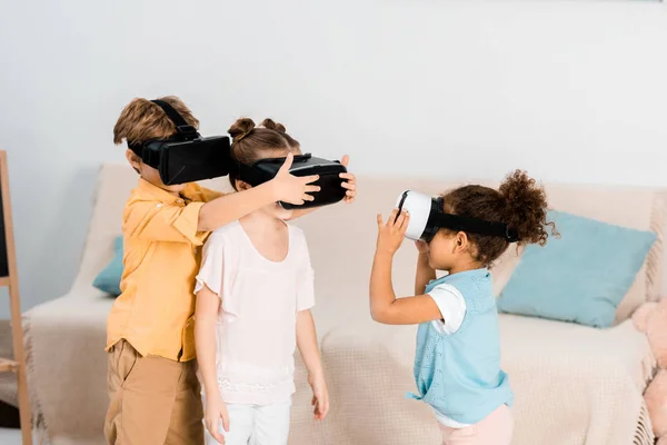 niño adorable sentado en la cama en casa con auriculares vr y jugando  videojuegos interactivos, explorando la realidad virtual. niño lindo con gafas  vr. futuro, gadgets, tecnología, educación en línea. 15940705 Foto