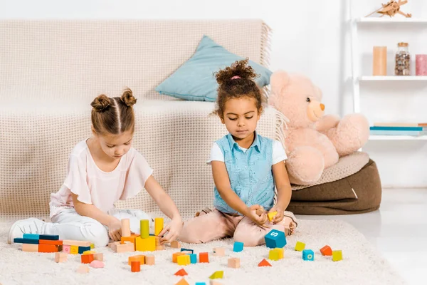 Hermosos Niños Multiétnicos Pequeños Sentados Alfombra Jugando Con Cubos Colores —  Fotos de Stock