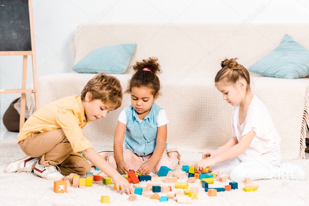 cute little children playing with colorful cubes on carpet  