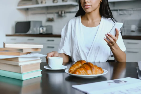 Avskårne Bilder Blandingsjente Hvit Kappe Med Smarttelefon Kaffe Morgenen Kjøkkenet – stockfoto