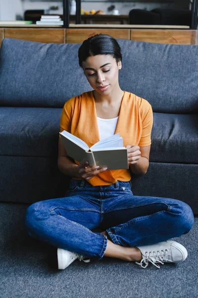 Bela Menina Raça Mista Camisa Laranja Leitura Livro Chão Sala — Fotografia de Stock