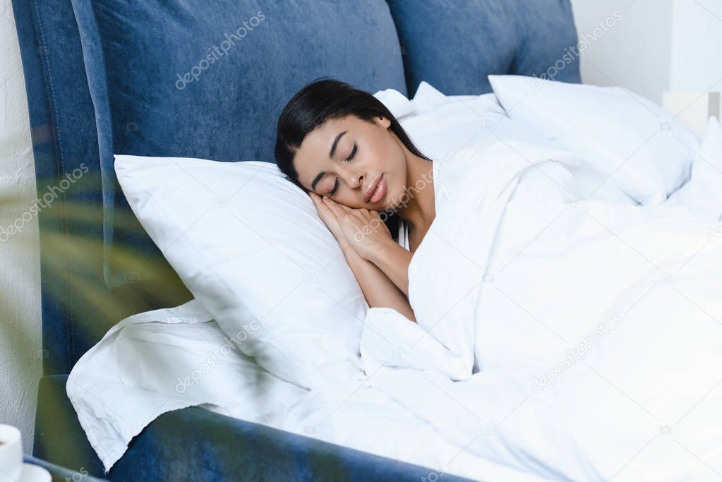 attractive mixed race girl sleeping on bed in morning