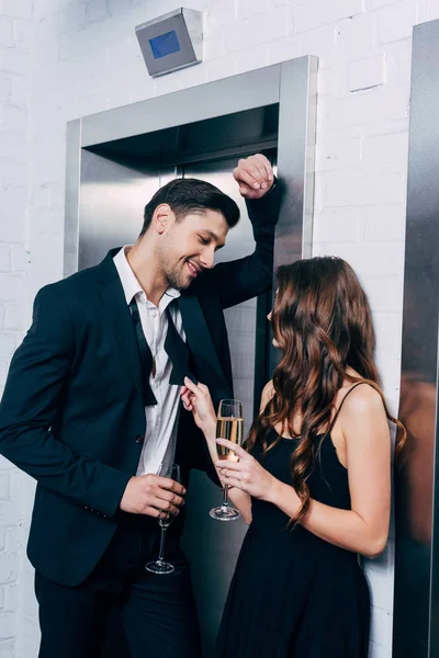 Couple Formal Wear Holding Champagne Glasses Talking Waiting Elevator — Stock Photo, Image