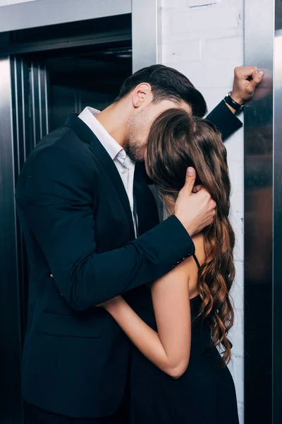 Мужчина Костюме Страстно Целует Обнимает Женщину Возле Лифта — стоковое фото