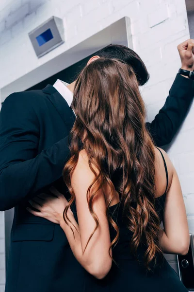 男人在西装激情亲吻女人附近的电梯 — 图库照片