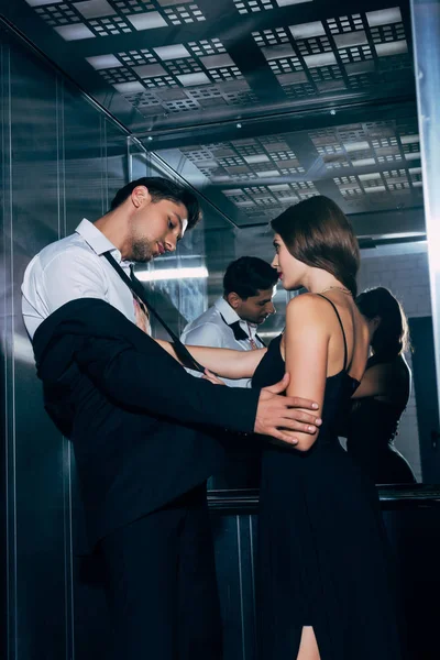 エレベーターの中でお互いに情熱的に触れて美しいカップル — ストック写真