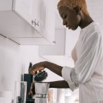 Afro-américaine femme préparant des boissons dans la cafetière