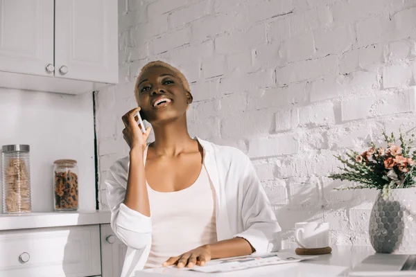 Mujer Afroamericana Hablando Smartphone Riendo Cocina Blanca — Foto de stock gratuita