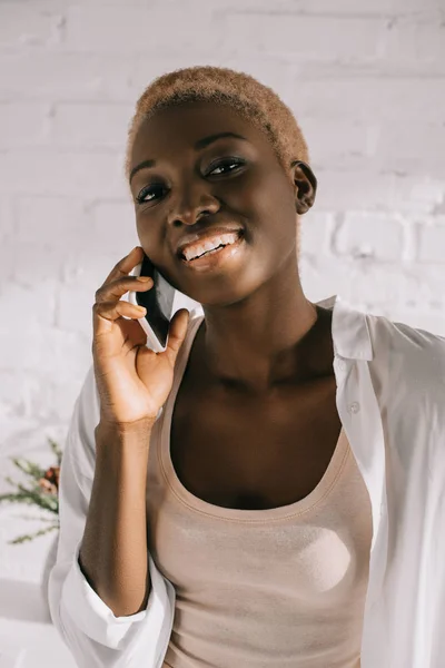 Afroamerikanerin Mit Kurzen Haaren Lächelt Und Spricht Auf Smartphone — kostenloses Stockfoto