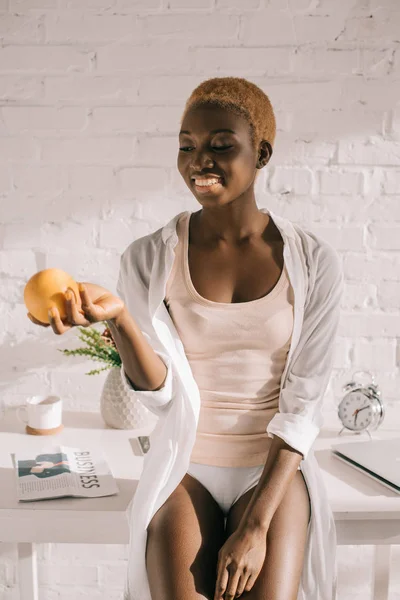 Mulher Americana Africana Feliz Com Cabelo Curto Segurando Laranja Cozinha — Fotos gratuitas