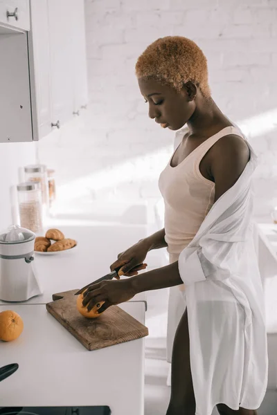 Beautiful African American Woman Cutting Orange Chopping Board — Free Stock Photo