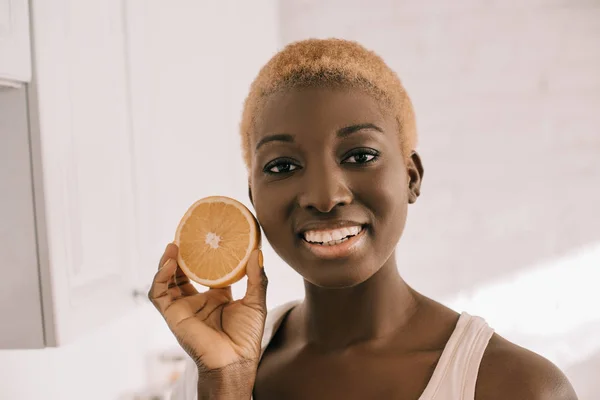 Close Cheerful African American Woman Holding Half Orange — Free Stock Photo