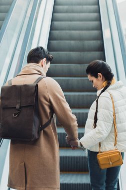 Elele ve yürüyen merdiven çıkmayı güzel çift