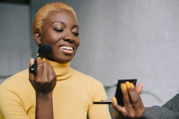 Glückliche Afroamerikanerin Trägt Puder Mit Kosmetikpinsel Auf — Stockfoto