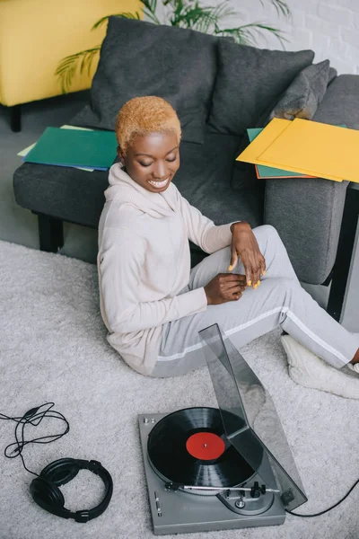 African American Woman Smiling Sitting Carpet Record Player — Free Stock Photo