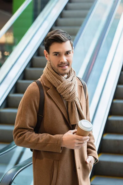 Handsome Man Standing Escalator Smiling Holding Disposable Cup — Free Stock Photo