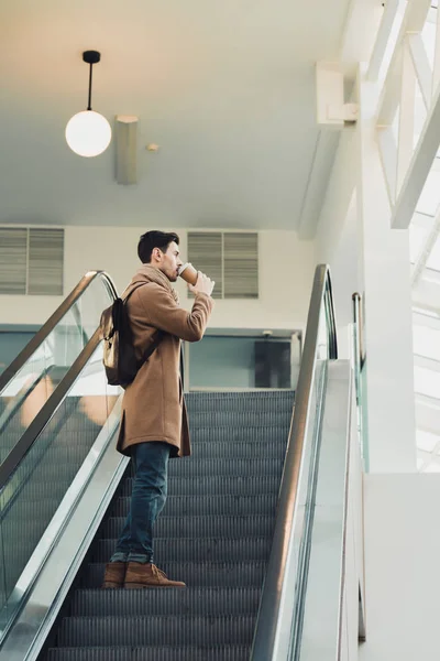 Handsome Man Going Escalator Drinking Disposable Cup — Free Stock Photo