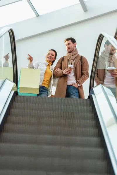 Chica Atractiva Con Bolsas Compras Apuntando Con Dedo Mano Hombre — Foto de stock gratuita