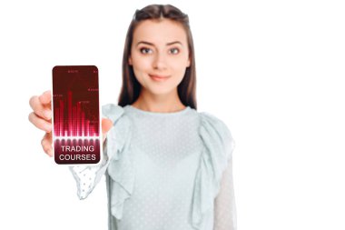 Genç kadın üzerinde beyaz izole smartphone ticaret kursları yazı ile gösterilen