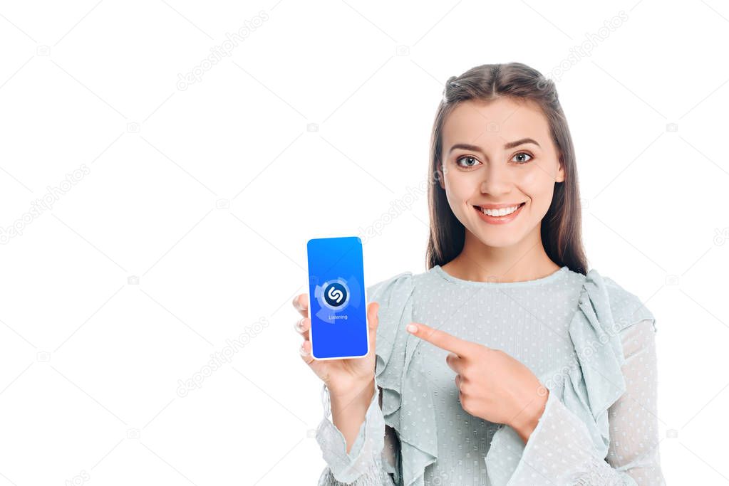 Smiling woman showing smartphone with shazam logo on screen isolated on white
