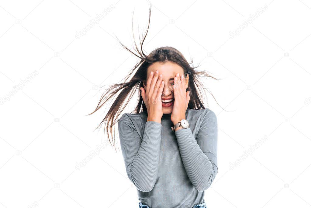 obscured view of happy woman covering face isolated on white