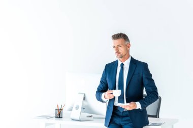 kahve tutarak ve üzerinde beyaz izole kamera bakarak yakışıklı işadamı
