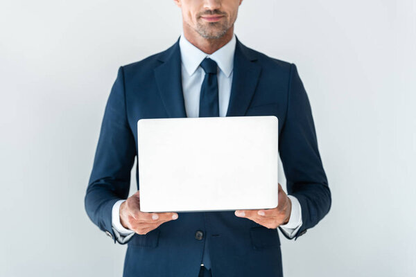 cropped image of businessman holding laptop isolated on white