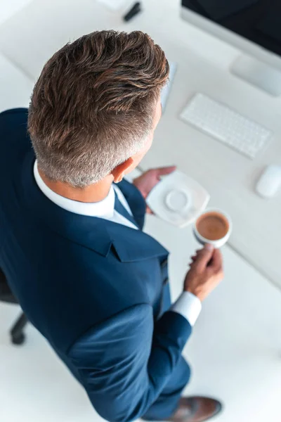 Pohled Vysoké Úhlu Podnikatele Držící Šálek Kávy Desku Úřadu — Stock fotografie zdarma