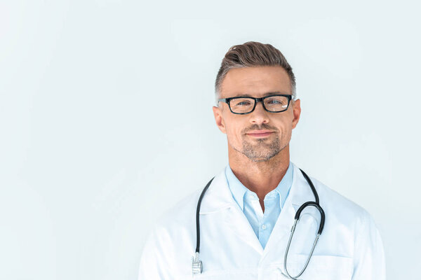handsome doctor in glasses with stethoscope on shoulders looking at camera isolated on white