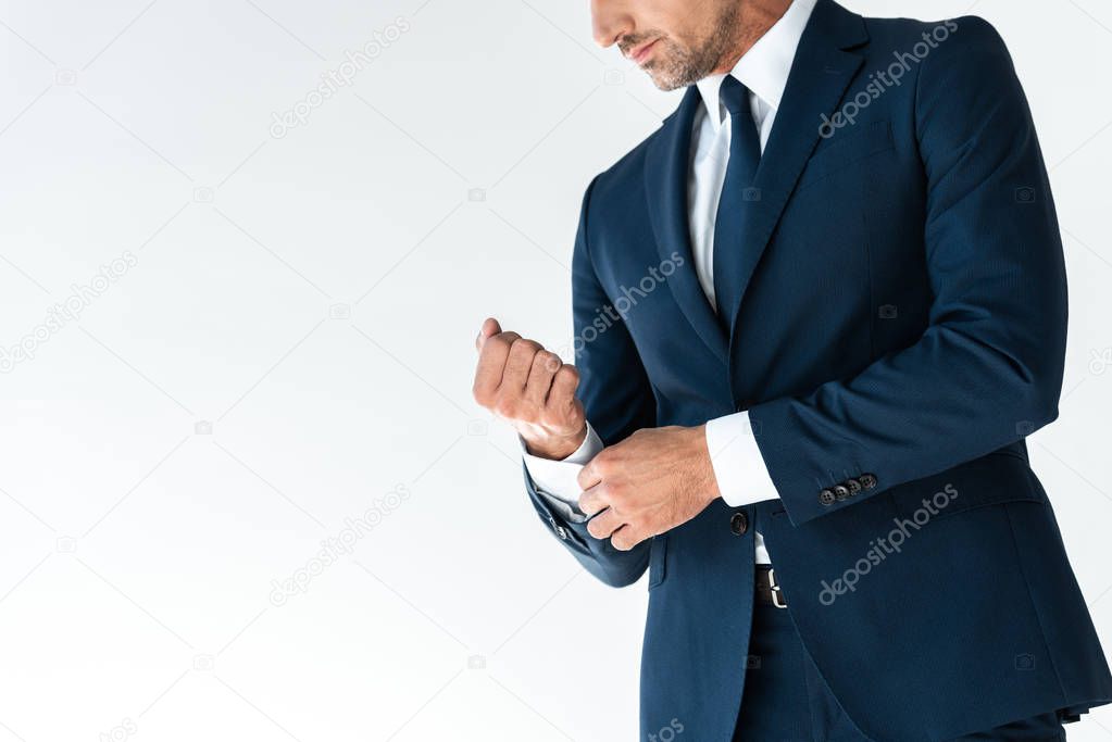 cropped image of businessman buttoning cuff isolated on white