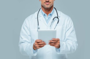 Beyaz önlük beyaz izole tablet tutan Doktor kırpılmış görüntü
