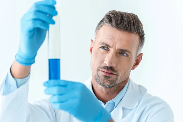 Selective Focus Handsome Scientist Looking Test Tube Blue Reagent Isolated — Stock Photo, Image