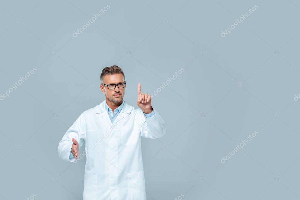 Handsome scientist in glasses touching something in air isolated on grey, artificial intelligence concept