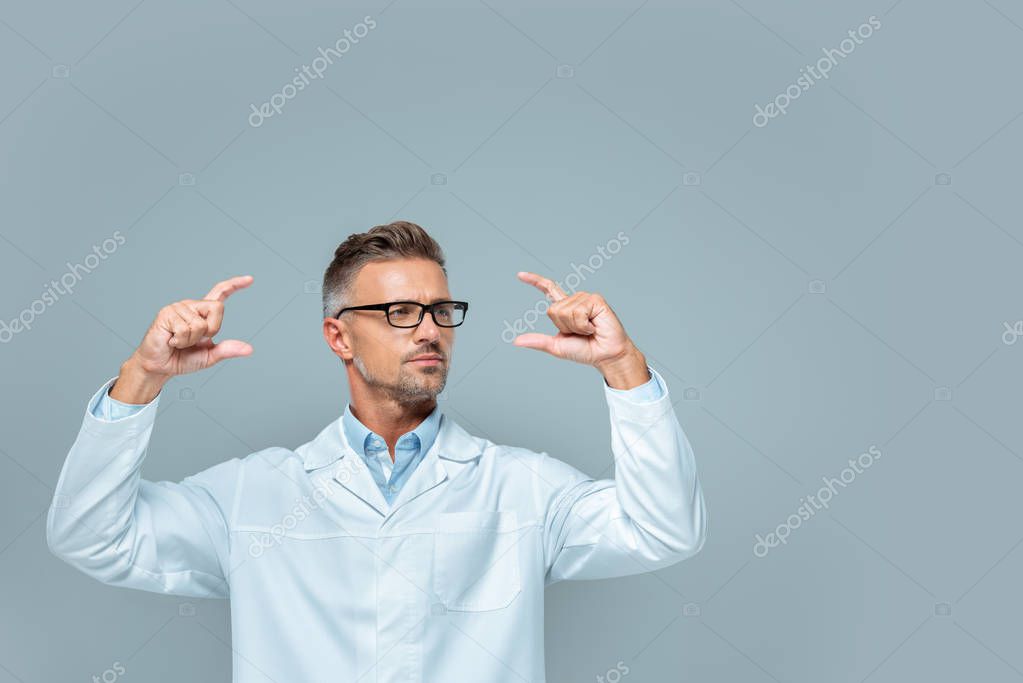 Handsome scientist in glasses holding something isolated on grey, artificial intelligence concept