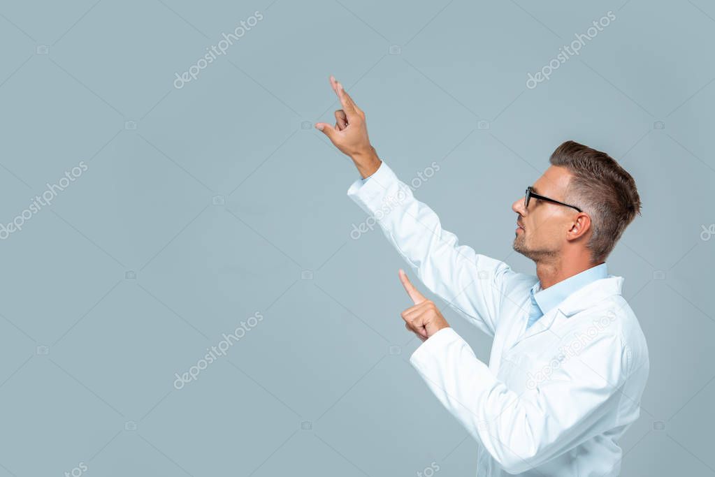 Side view of handsome scientist in glasses moving something isolated on grey, artificial intelligence concept