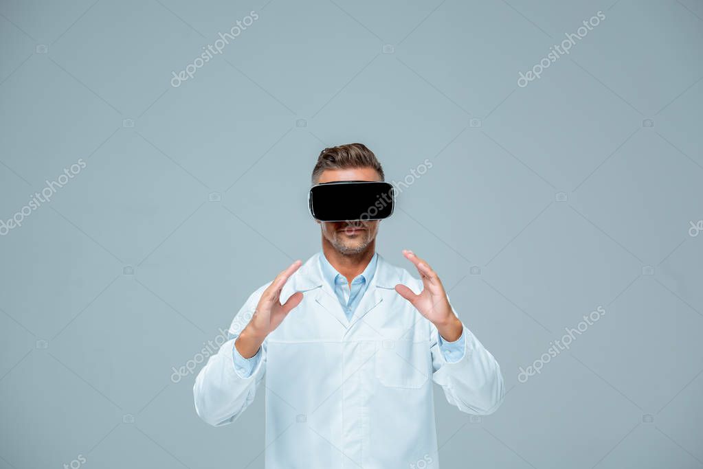 Scientist in virtual reality headset holding something isolated on grey, artificial intelligence concept