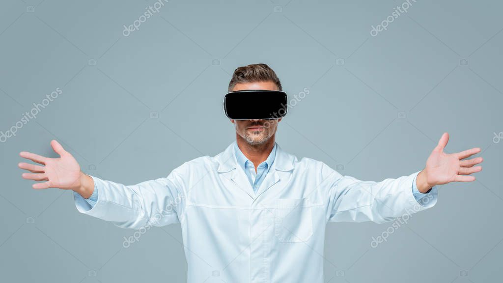 Scientist in virtual reality headset holding something in air isolated on grey, artificial intelligence concept