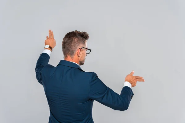 Visión Trasera Hombre Negocios Gafas Tocando Algo Aislado Gris Concepto — Foto de stock gratis