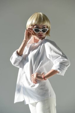şık beyaz kıyafeti üzerinde beyaz izole güneş gözlüğü üzerinde seyir çekici sarışın kadın