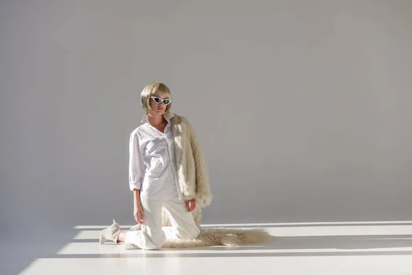 Modeshooting Der Attraktiven Frau Winteroutfit Mit Kunstpelzmantel Auf Knien Stehend — kostenloses Stockfoto